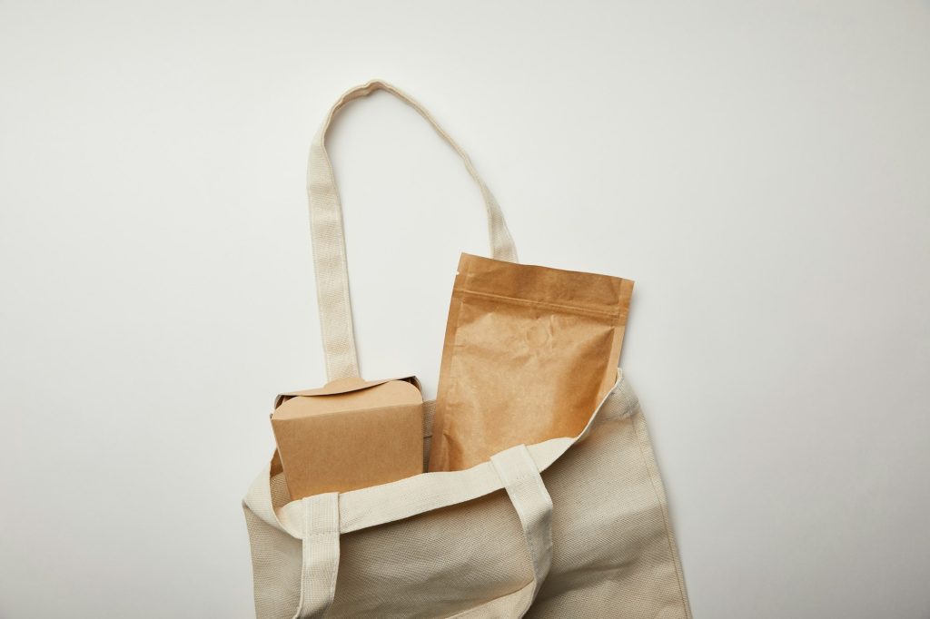 top view of cotton bag with cardboard noodle box on white surface